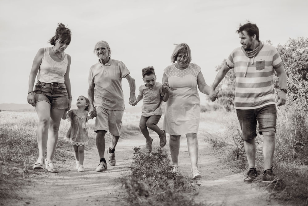 Fotografia de llum natural de família - passeig familiar amb tres generacions